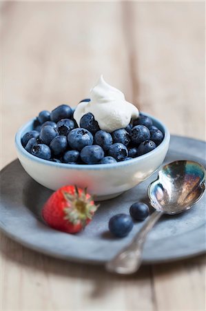 simsearch:659-07027529,k - Fresh Blueberries with Whipped Cream in a Bowl; Strawberry and Spoon Foto de stock - Sin royalties Premium, Código: 659-07597236