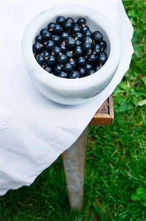 Blackcurrants in a marble bowl on a table outdoors Stock Photo - Premium Royalty-Free, Code: 659-07597316