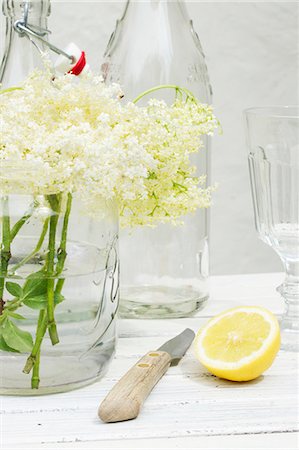 pflanzliches heilmittel - A still life featuring elderflowers, lemon, bottles and a knife Stockbilder - Premium RF Lizenzfrei, Bildnummer: 659-07597320