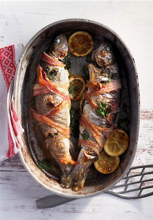 Trout wrapped in bacon in a roasting tin Foto de stock - Sin royalties Premium, Código: 659-07597381