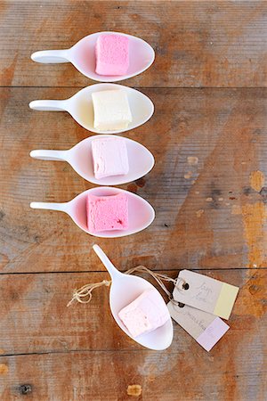 süßigkeiten - A row of marshmallows in spoons, on a wooden surface Stockbilder - Premium RF Lizenzfrei, Bildnummer: 659-07597474