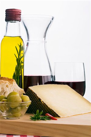 A still life featuring olive oil, red wine, bread, olives and Manchego (Spain) Stock Photo - Premium Royalty-Free, Code: 659-07597579