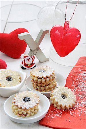 Jam-filled ring biscuits, Xmas, a fabric heart, a glass heart and Father Christmas Stock Photo - Premium Royalty-Free, Code: 659-07597586