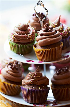 Chocolate cupcakes with sugar pearls on a tiered cake stand Foto de stock - Sin royalties Premium, Código: 659-07597631