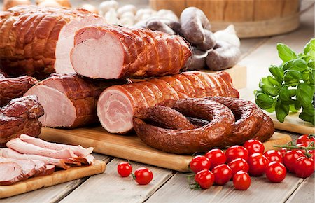 Assorted sausages and ham, cherry tomatoes, basil and garlic Stockbilder - Premium RF Lizenzfrei, Bildnummer: 659-07597658