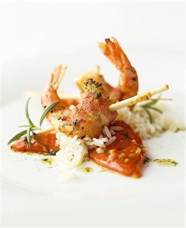 Prawns wrapped in bacon on a bed of rice Photographie de stock - Premium Libres de Droits, Code: 659-07597677