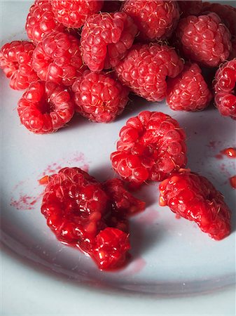 Several raspberries, some crushed Stock Photo - Premium Royalty-Free, Code: 659-07597844