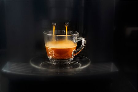 Coffee flowing from an espresso machine into a glass cup Foto de stock - Sin royalties Premium, Código: 659-07597842