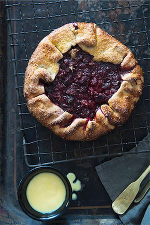 fruit cake top view - Raspberry galette (a rustic tart) on a cooling rack, and a pot of custard Stock Photo - Premium Royalty-Free, Code: 659-07597930