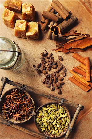 Assorted spices on a wooden table (cinnamon bark, cinnamon sticks, star anise, cardamom and palm sugar) Photographie de stock - Premium Libres de Droits, Code: 659-07598321