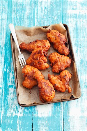 Deep-fried chicken wings and legs in beer batter on a baking tray Photographie de stock - Premium Libres de Droits, Code: 659-07598476