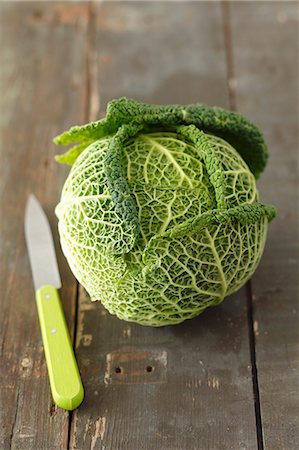 repollo - A young savoy cabbage on a wooden surface with a knife Foto de stock - Sin royalties Premium, Código: 659-07598575