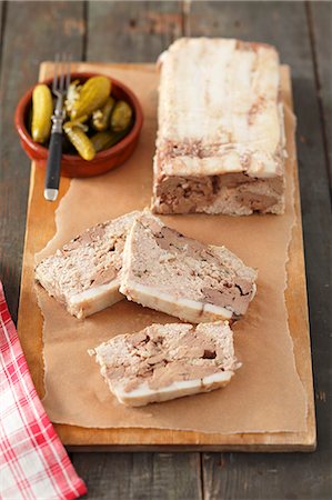 simsearch:659-06187583,k - Pâté with chicken liver, partly sliced, and a small bowl of pickled gherkins Foto de stock - Royalty Free Premium, Número: 659-07598610