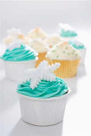 pasteles de navidad - Cupcakes decorated with green and yellow frosting and snowflakes Photographie de stock - Premium Libres de Droits, Code: 659-07598680