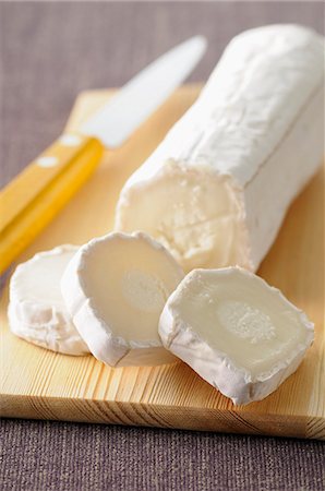 Slice of Goats Cheese with Goat Cheese Log Stock Photo - Premium Royalty-Free, Code: 659-07598740