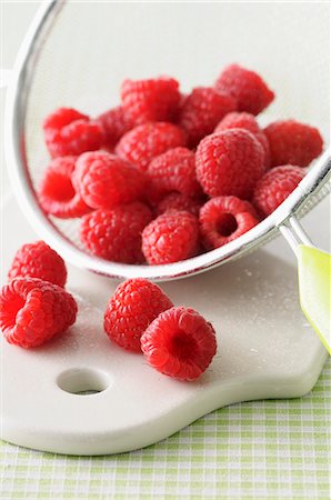 simsearch:659-03537384,k - Fresh raspberries in a sieve on a chopping board Foto de stock - Royalty Free Premium, Número: 659-07598742