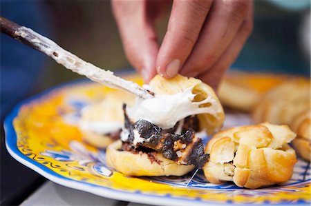 Making smores: filling profiteroles with hazelnut spread and marshmallow Stock Photo - Premium Royalty-Free, Code: 659-07598800