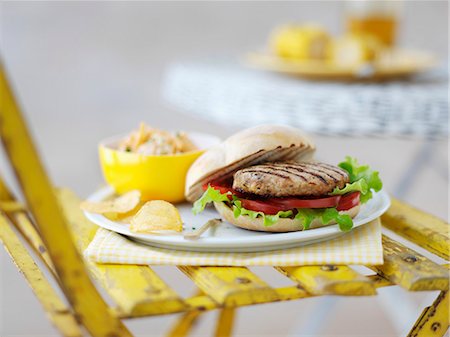 Grilled turkey burger in a bun with crisps Stock Photo - Premium Royalty-Free, Code: 659-07598825