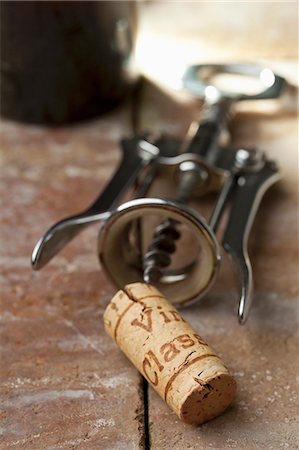 A wine cork with a corkscrew and a bottle of wine Stock Photo - Premium Royalty-Free, Code: 659-07599006