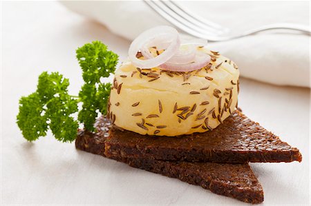 queso - A roll of handmade Harzer (sour milk cheese) with caraway seeds and onions on pumpernickel bread Foto de stock - Sin royalties Premium, Código: 659-07599018