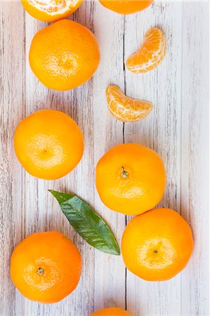 Sections of and whole clementine oranges and a leaf Foto de stock - Sin royalties Premium, Código: 659-07599125