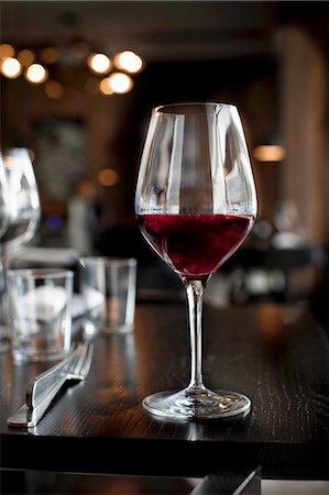 A glass of red wine on a table in a restaurant Stock Photo - Premium Royalty-Free, Code: 659-07599203