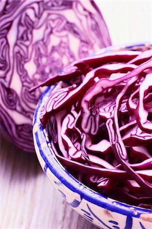 Sliced red cabbage in a bowl in front of half a red cabbage Stock Photo - Premium Royalty-Free, Code: 659-07599246