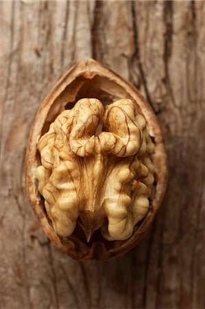 simsearch:659-08897176,k - Half a walnut against a wooden surface (close-up) Foto de stock - Sin royalties Premium, Código: 659-07599249