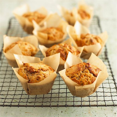 pâtisserie - Several apple & walnut muffins in baking parchment on a wire rack Photographie de stock - Premium Libres de Droits, Code: 659-07599333