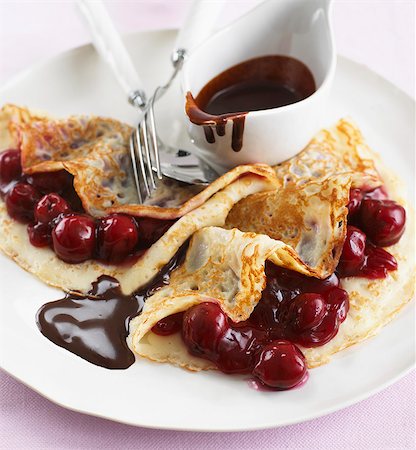 Pancakes with cherries and chocolate sauce Fotografie stock - Premium Royalty-Free, Codice: 659-07599355