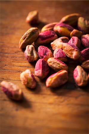 pistachio kernel - Shelled pistachios on a wooden surface Stock Photo - Premium Royalty-Free, Code: 659-07609696