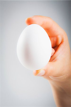 ei (speise) - A woman's hand holding a white egg Stockbilder - Premium RF Lizenzfrei, Bildnummer: 659-07609701