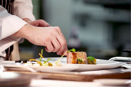 Chef plating up pork dish during service at working restaurant Photographie de stock - Premium Libres de Droits, Code: 659-07609758