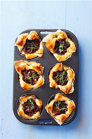 simsearch:659-06903094,k - Puff pastry tartlets with sundried tomatoes, caramelised onions and thyme Foto de stock - Sin royalties Premium, Código: 659-07609834