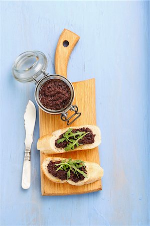 spreading - Slices of baguette with tapenade and rocket Stock Photo - Premium Royalty-Free, Code: 659-07609842