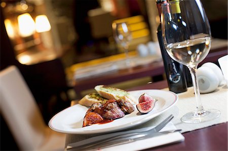 simsearch:659-07610237,k - a view on the interior of the restaurant, a table with wine and a dish of grilled liver with figs Photographie de stock - Premium Libres de Droits, Code: 659-07609930