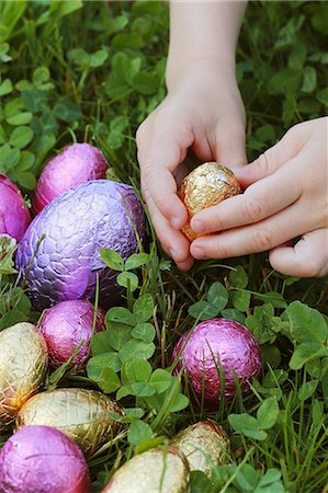 simsearch:659-06373157,k - Child's hand reaching for a chocolate egg in a field Stock Photo - Premium Royalty-Free, Code: 659-07610027
