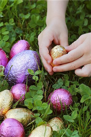 simsearch:659-06670903,k - Child's hand reaching for a chocolate egg in a field Photographie de stock - Premium Libres de Droits, Code: 659-07610027