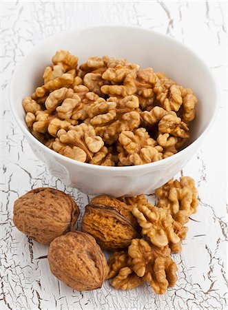 simsearch:659-07609880,k - A bowl of walnuts with a whole nuts and shelled nuts in front of it Stock Photo - Premium Royalty-Free, Code: 659-07610046