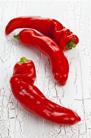 simsearch:659-07027873,k - Three red pointed peppers on a white wooden table Photographie de stock - Premium Libres de Droits, Code: 659-07610059