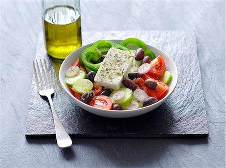 ensalada griega - A Greek salad next to a bottle of olive oil Foto de stock - Sin royalties Premium, Código: 659-07610096