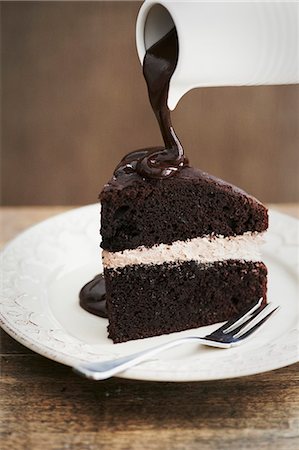 simsearch:659-06900815,k - A slice of chocolate cake with a cream filling and chocolate sauce Stock Photo - Premium Royalty-Free, Code: 659-07610102