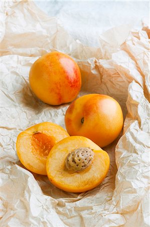 simsearch:659-07610349,k - Whole and halved nectacots (a cross between a nectarine and an apricot) Foto de stock - Sin royalties Premium, Código: 659-07610350