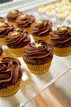 simsearch:659-08418895,k - Chocolate fudge cupcakes decorated with stars Photographie de stock - Premium Libres de Droits, Code: 659-07610398