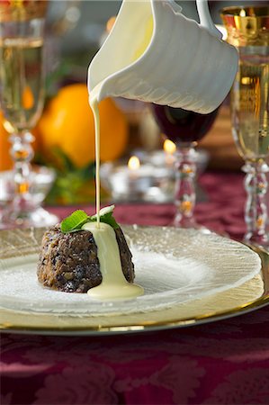 Custard being poured over Christmas pudding Stock Photo - Premium Royalty-Free, Code: 659-07738919