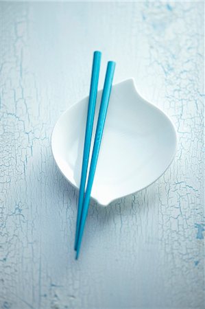 palillo (oriental) - Blue chopsticks balanced over a white bowl Foto de stock - Sin royalties Premium, Código: 659-07739112