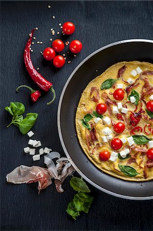 dish with eggs - A breakfast omelette with tomatoes, feta cheese, ham and basil Stock Photo - Premium Royalty-Free, Code: 659-07739312