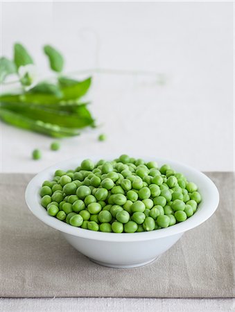 pisello - A bowl of fresh peas with pea pods in the background Fotografie stock - Premium Royalty-Free, Codice: 659-07739321