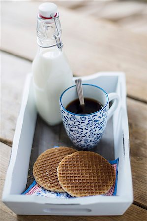 A cup of coffee, syrup waffles and a bottle of milk on a tray Foto de stock - Sin royalties Premium, Código: 659-07739535