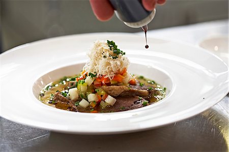 Prime boiled beef in broth being drizzled with balsamic vinegar Stock Photo - Premium Royalty-Free, Code: 659-07739579